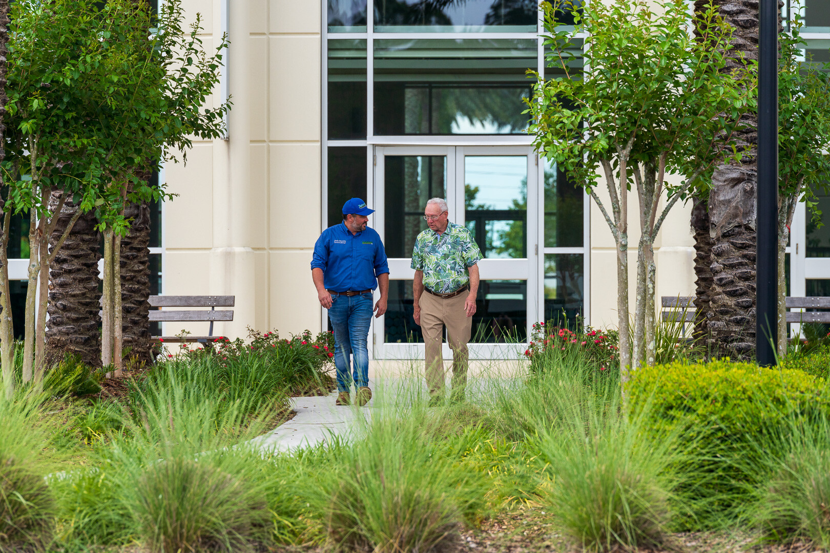 commercial maintenance account manager and customer inspecting planting beds with grasses and trees 2-1