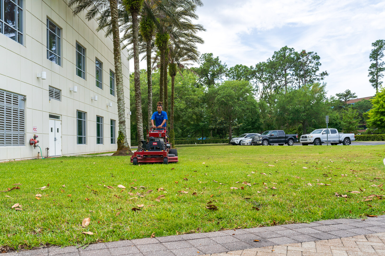 commercial maintenance technician mowing lawn in front of church 2