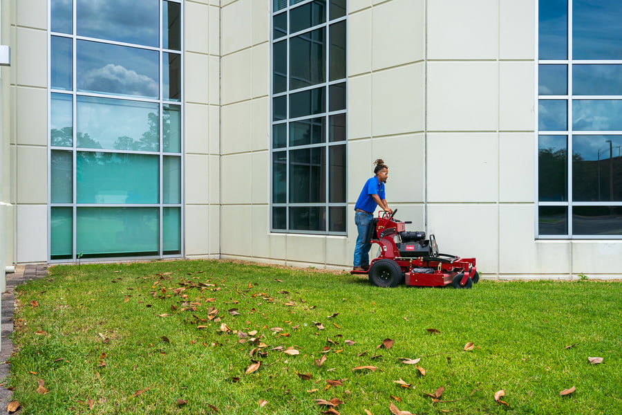 commercial maintenance technician mowing lawn in front of church