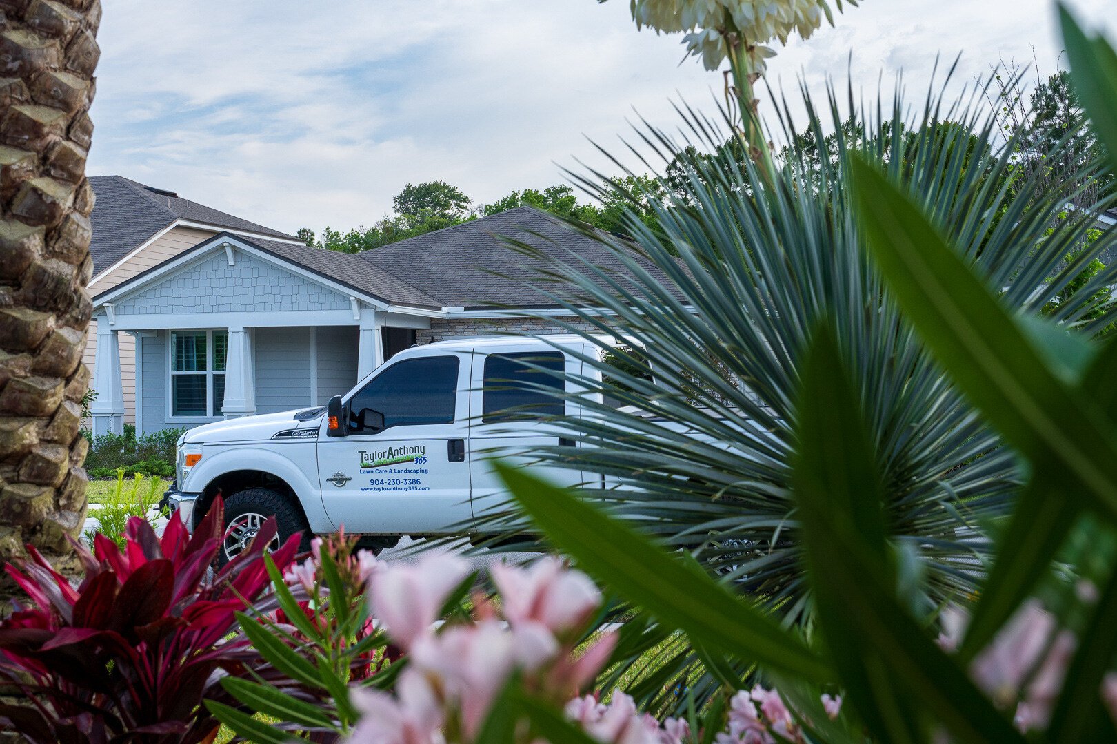 landscape planting bed with a maintenance company truck in the background