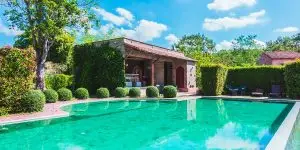 Lush tropical pool landscaping in Ponte Vedra Beach featuring trimmed hedges, manicured shrubs, and privacy greenery surrounding a backyard pool.